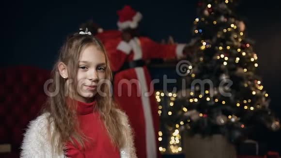 小可爱的女孩把手指放在嘴唇上要求安静而圣诞老人送礼物视频的预览图