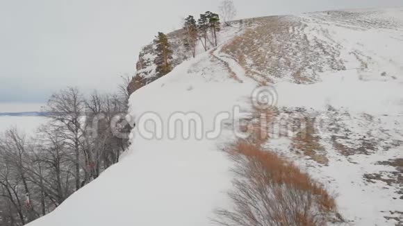 鸟瞰两个雄性徒步旅行者在未触及的雪山景观中行走旅游旅行的人的风景视频的预览图