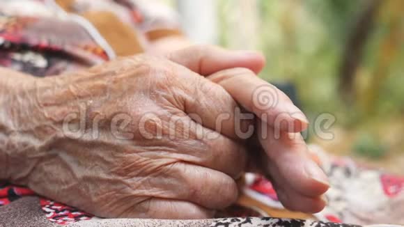 在外面的老女人皱着胳膊祖母在户外抚摸她的手关闭侧视视频的预览图