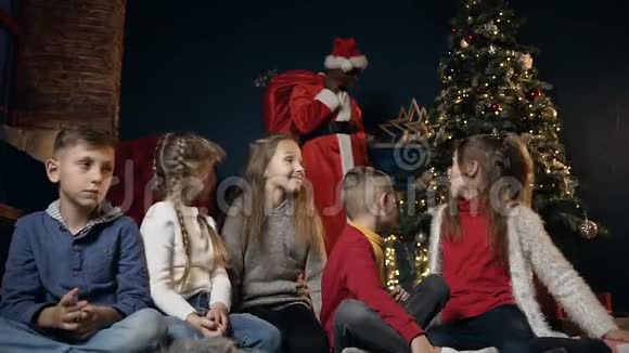 快乐可爱的孩子玩笑和给予五个背景与非洲男人在圣诞老人服装视频的预览图