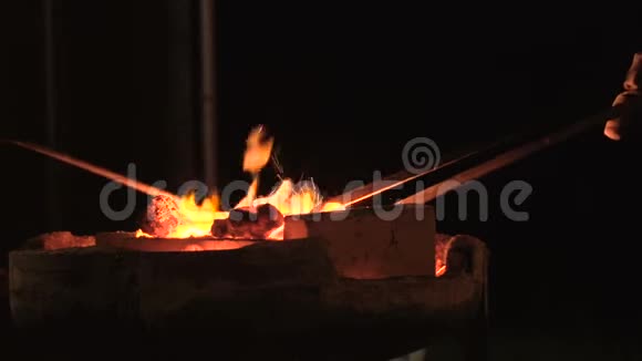 用火钳在一个非常热的锻炉中熔炉的慢速运动视频的预览图