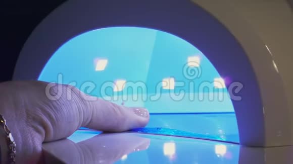 女人把指甲油涂在紫外线干燥处视频的预览图
