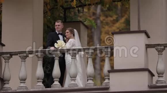 美丽的新婚夫妇站在秋天的阳台上背景是森林视频的预览图