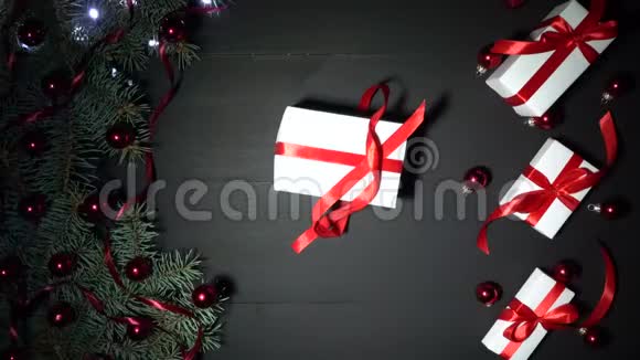 曼斯双手包一件礼物黑色的圣诞背景装饰着彩灯视频的预览图