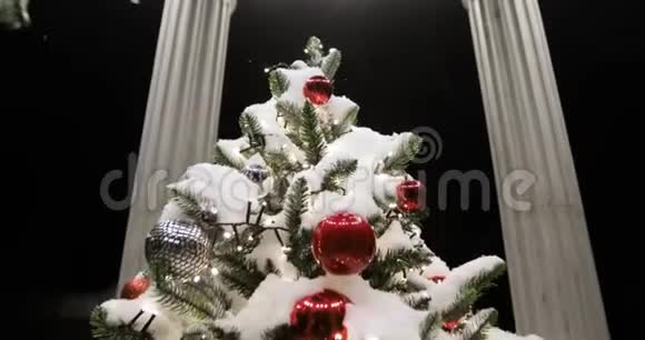 在神圣的夜晚凉亭里的圣诞树覆盖着雪上面有玩具和花环视频的预览图
