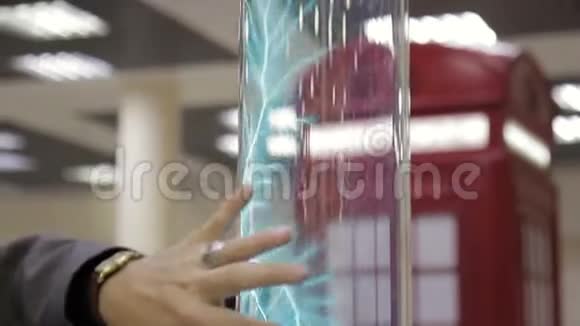 在科学展览上人类正在用电子仪器触摸玻璃圆筒并将其关闭视频的预览图