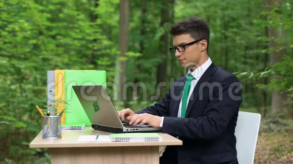 穿着商务服的快乐男人在绿色美丽的森林视频的预览图