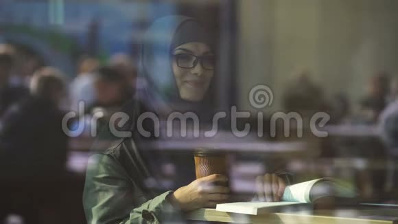 年轻的阿拉伯女学生在咖啡馆看书准备考试文学视频的预览图