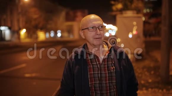 一个年老的人在夜晚照耀着城市城市灯光背景视频的预览图