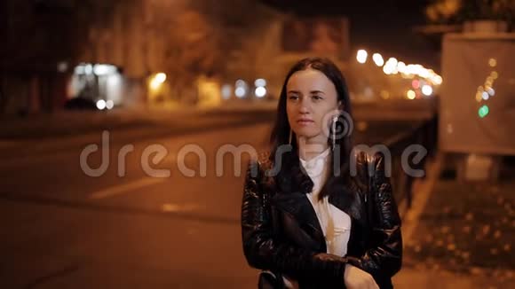 美丽的年轻女子对抗夜光城市城市灯光背景视频的预览图