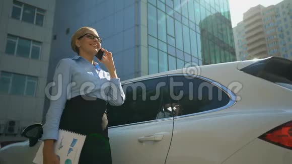 女商人在汽车附近打电话解决办公室附近的商业问题视频的预览图