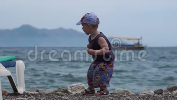 一个小可爱的男孩慢吞吞地扔石头视频的预览图
