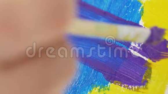 特写艺术家画笔用美丽的颜色给画着色视频的预览图