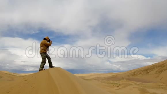 在戈壁沙漠给杜恩斯拍照的游客视频的预览图