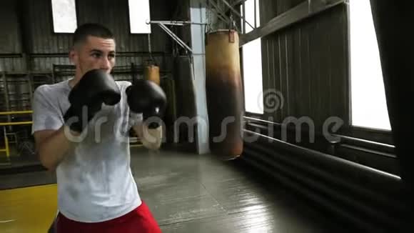 英俊的年轻男性训练在健身房里打沙袋勤劳的拳击手有效地用拳打脚踢视频的预览图