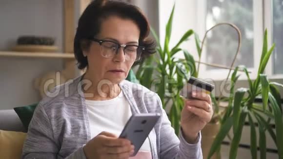 戴眼镜的成熟女人在网上购物视频的预览图