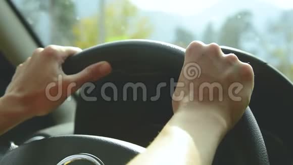 打开光圈的特写那个女孩在乡间小路上开车女人把手放在方向盘上视频的预览图