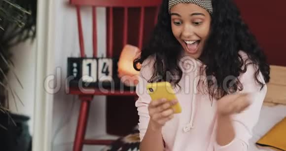 美女年轻女子用智能手机笑看惊喜享受好消息用智能手机和朋友聊天视频的预览图