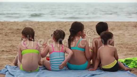 孩子们在海滩上吃三明治视频的预览图