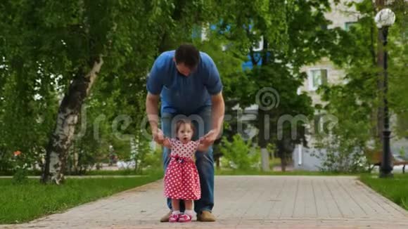 爸爸带着小宝宝去公园孩子学会走路带孩子的家长步行视频的预览图