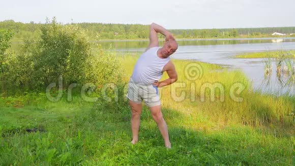 早上在湖边做伸展运动的老人视频的预览图