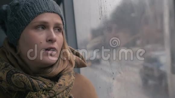 一个忧郁的雨天坐在公共汽车上的年轻悲伤的女人视频的预览图