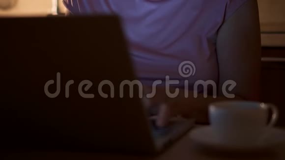 高级女性在使用笔记本电脑时喝杯咖啡家庭办公室夜班自由职业者视频的预览图