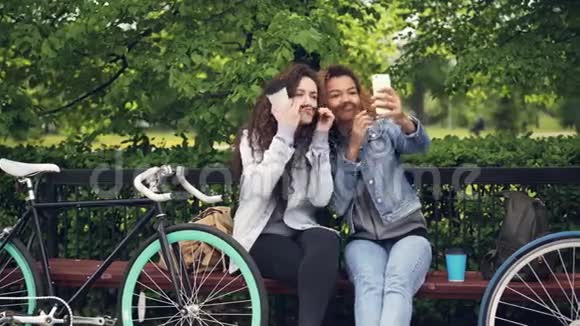 开朗的白种人和非洲裔美国女孩的朋友正在自拍用头发做胡子并与他们摆姿势视频的预览图