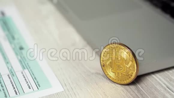 幻灯片比特币硬币在电脑笔记本电脑旁边的1040所得税退还表格概念比特币和视频的预览图