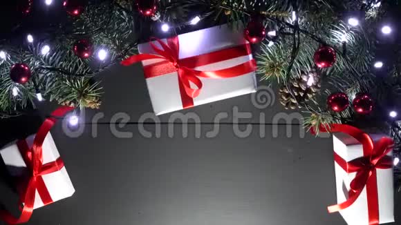 在木制背景上平躺着闪亮的蓝色圣诞灯上面有圣诞装饰和礼物视频的预览图