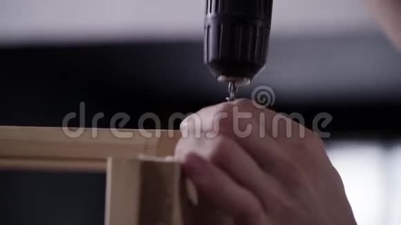 特写男徒手用现代电子螺丝刀连接木板视频的预览图