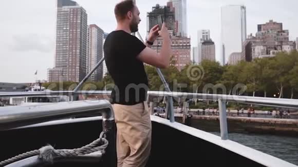 兴奋的白种人男性游客制作了一个智能手机视频纽约市天际线在一个旅游船旅行慢动作视频的预览图