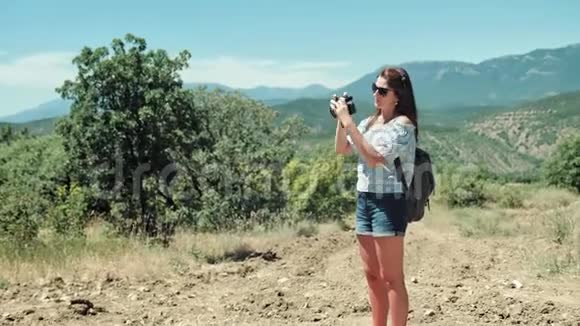专业女摄影师站在美丽的自然公园拍照视频的预览图