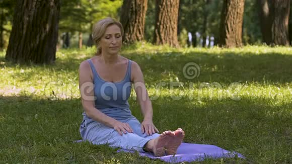 成人优雅地在公园展示瑜伽姿势业余健身视频的预览图