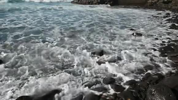 白色泡沫破碎的海浪在海滩上黑色火山沙在特内里夫视频的预览图