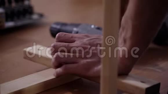 男的手正在用现代电子螺丝刀连接木板视频的预览图