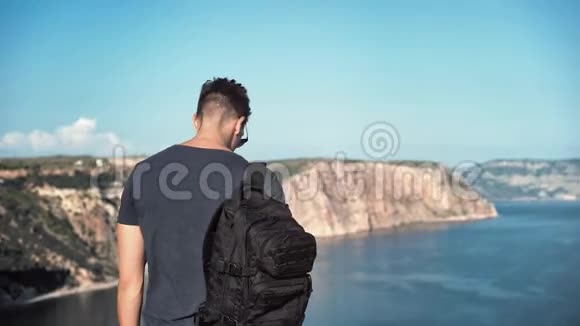 中弹背包欧洲男子戴墨镜欣赏令人惊叹的海港景色视频的预览图