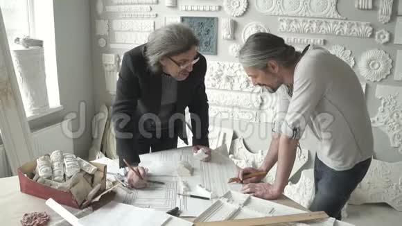 两个成熟的男建筑师站在桌边视频的预览图