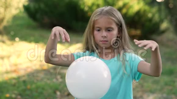 年轻女孩模仿巫师在白色球体上挥舞双手视频的预览图