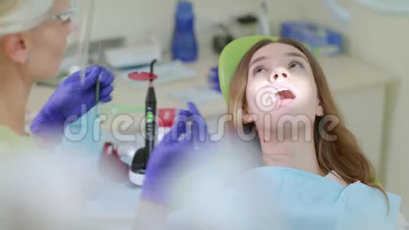 牙科办公室的牙齿治疗过程金发牙医为病人工作视频的预览图