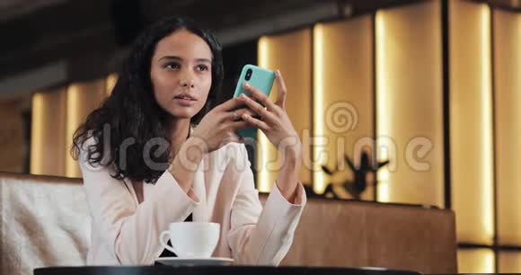 快乐的女人用智能手机说话听声音信息女孩在咖啡馆里使用移动语音控制做生意视频的预览图