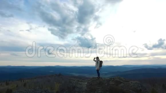 徒步旅行者站在山峰上环顾四周视频的预览图