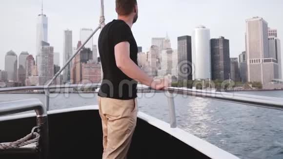 英俊兴奋的旅行者张开双臂享受着令人惊叹的纽约天际线在河流旅游船上慢动作视频的预览图