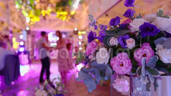 人们在婚礼上跳舞人们在花的背景上跳舞色彩鲜艳的婚礼派对视频的预览图