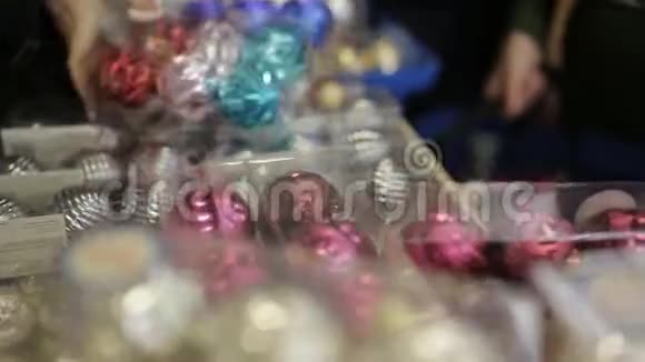 一群朋友在超市里挑选和摆放圣诞玩具的购物车颜色鲜艳的装饰物视频的预览图