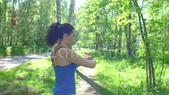 健康运动年轻女子跑步和看穿智能手表装置年轻的运动女性准备慢跑开始锻炼视频的预览图