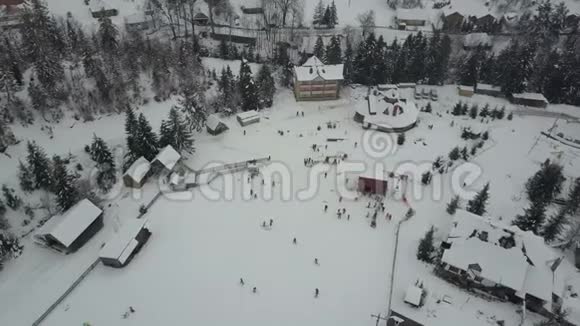 喀尔巴阡滑雪场从高处在滑雪电梯上飞行鸟人们在滑雪板和滑雪板上下降的视野视频的预览图