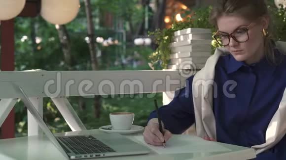 在一家夏季咖啡馆里写作的白人女商人业务战略视频的预览图