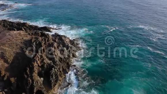 从荒芜海岸的高处眺望特内里费岛的岩石海岸空中无人机拍摄的海浪图像视频的预览图