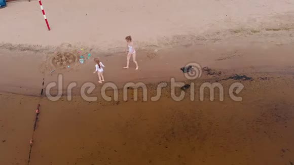 母女俩沿着沙滩沿着河跑海滩夏日阳光明媚空中射击视频的预览图